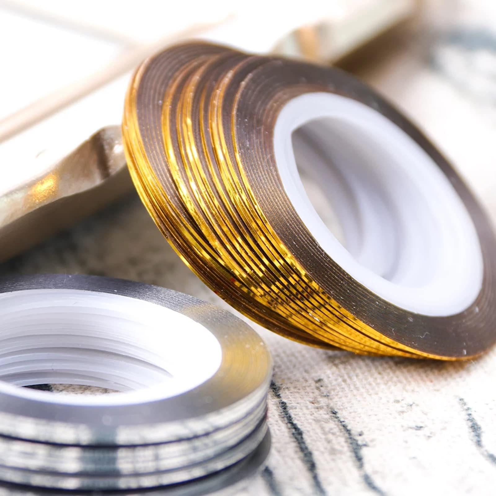 Assorted rolls of gold and silver nail decoration strips for professional nail art