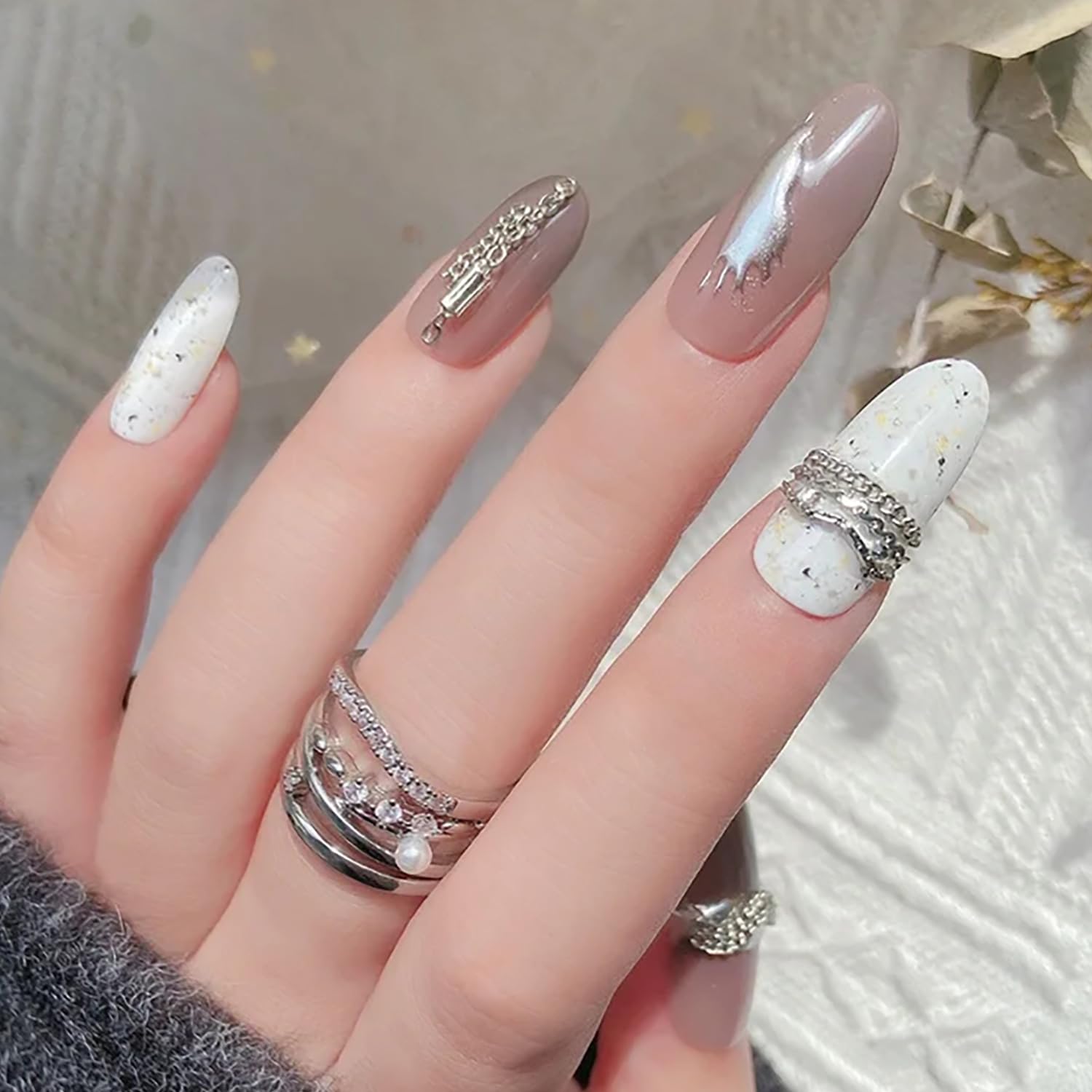Edgy punk style manicure featuring silver metal chains and caviar beads jewelry accents