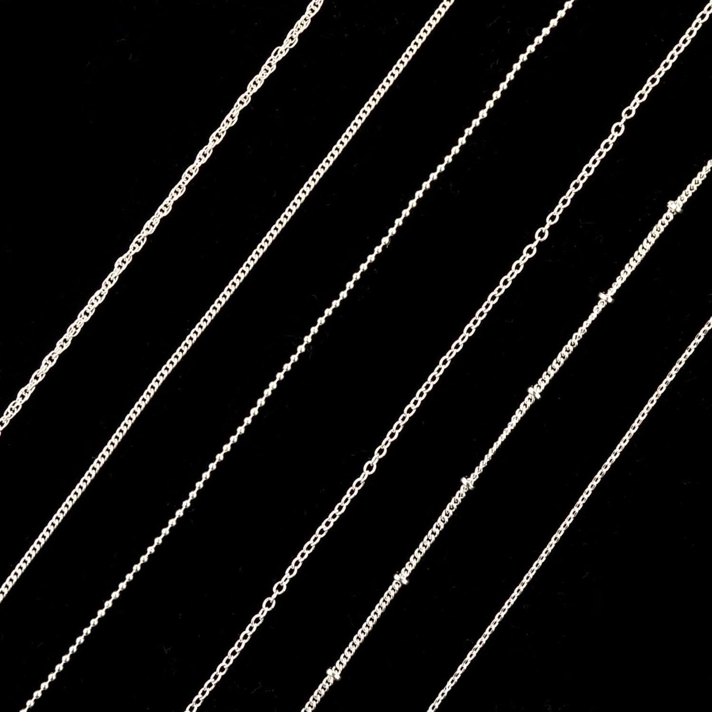 Applying authentic imported Sindy silver nail charms using tweezers on a polished nail
