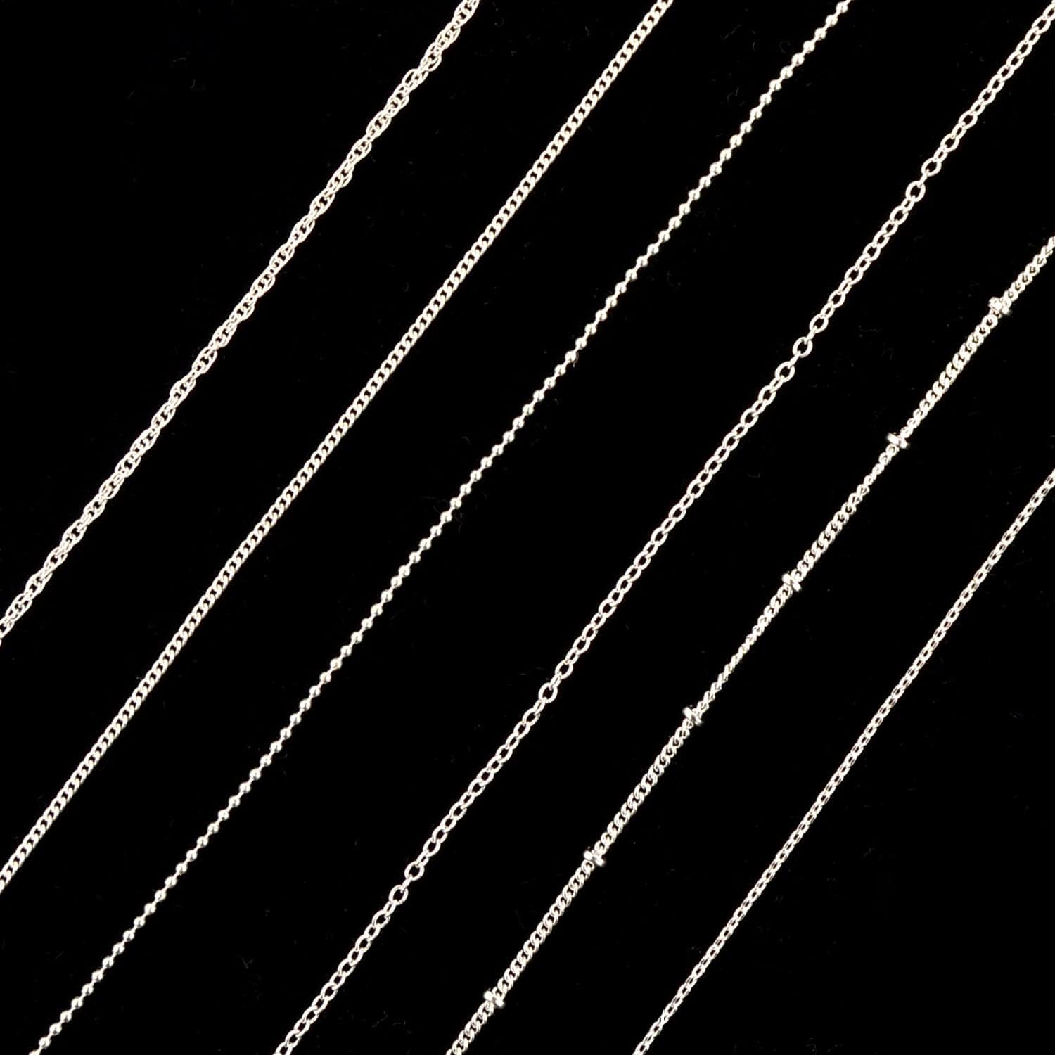 Applying authentic imported Sindy silver nail charms using tweezers on a polished nail