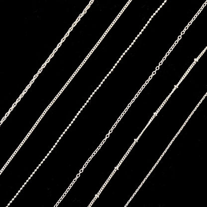 Applying authentic imported Sindy silver nail charms using tweezers on a polished nail