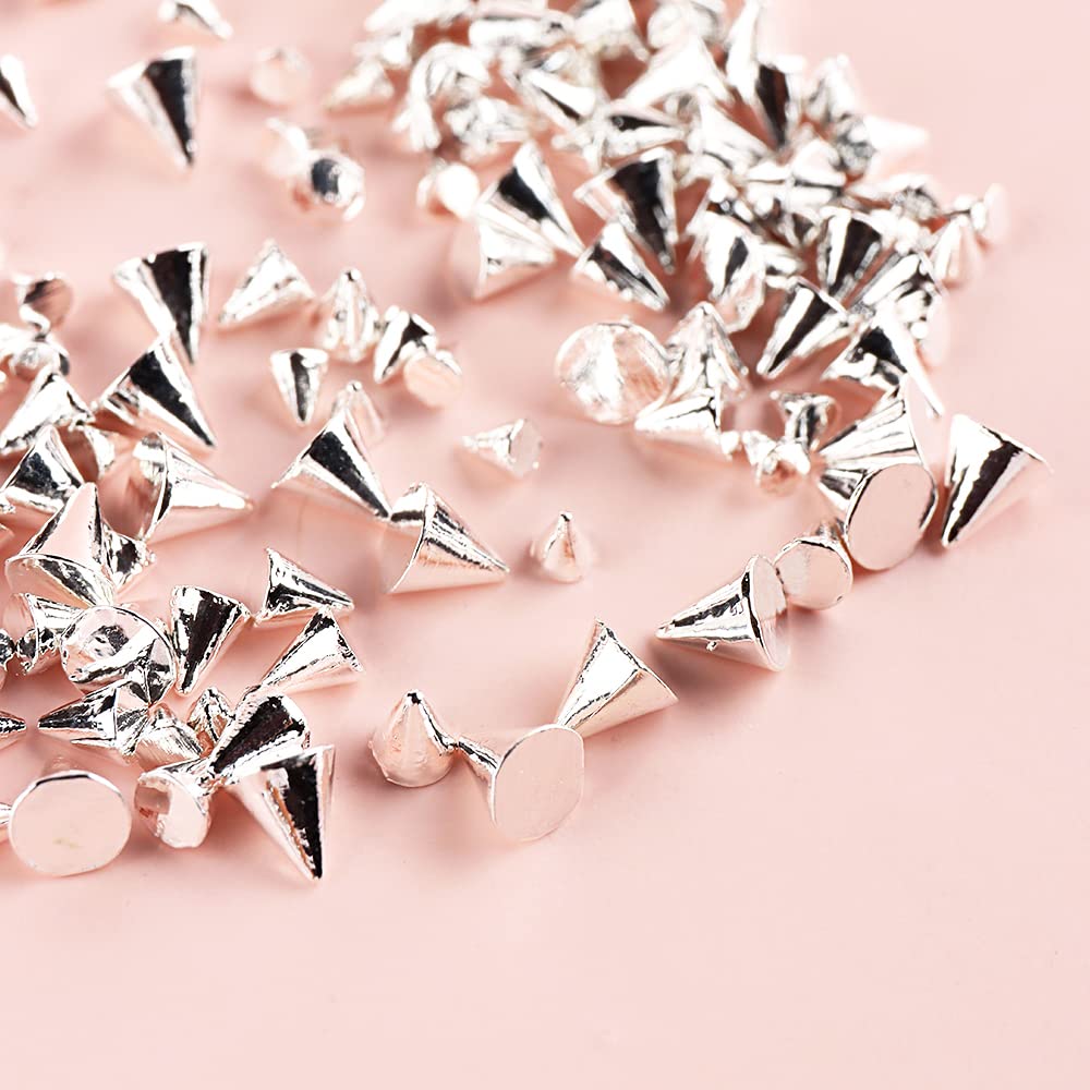 Assorted sizes of mini punk nail charms displayed next to professional manicure tools