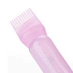 Pebipoo hair oil applicator bottle being used to distribute liquid on hair roots