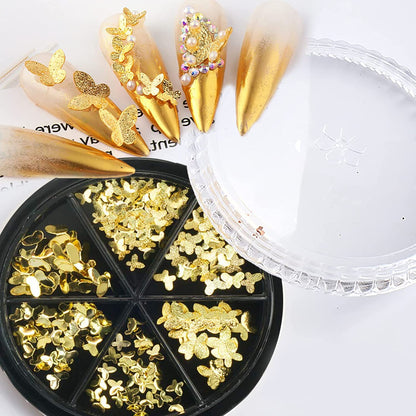 Assorted sizes of 3D metallic alloy butterfly nail studs showing smooth and textured gold surfaces.