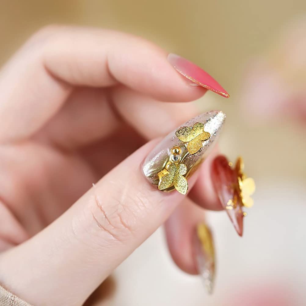 Closer shot of gold-toned butterfly nail sequins applied over neutral gel nail polish.