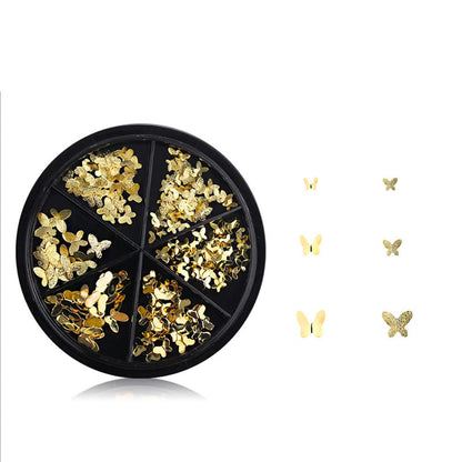 Flat lay of diverse gold butterfly nail jewelry shapes perfect for festive Indian manicure styles.