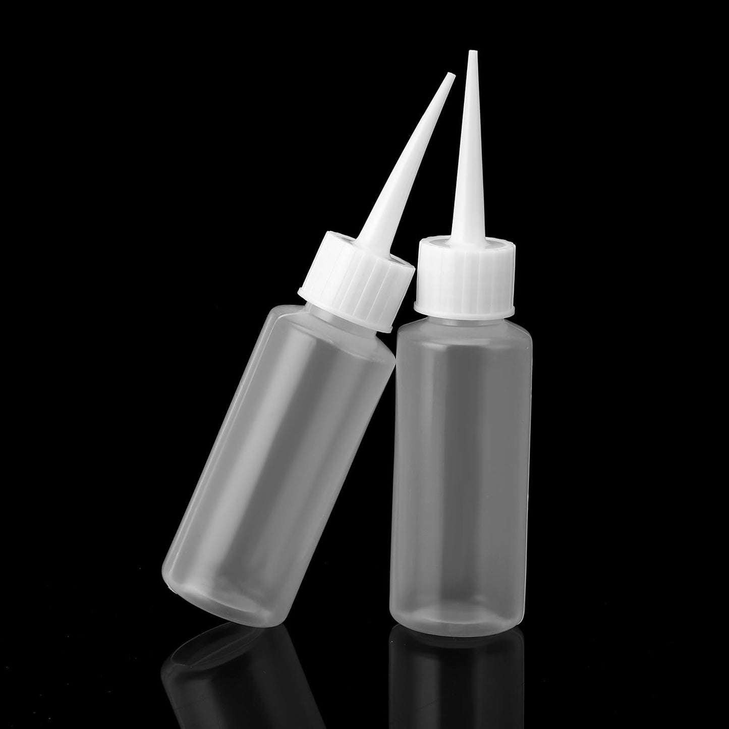 Top angle view of multiple empty transparent hair salon color bottles grouped together.