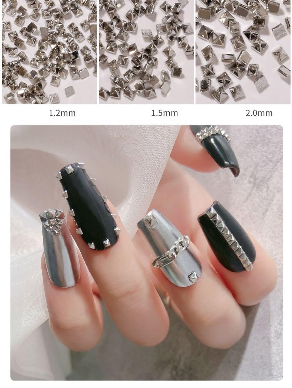 Close up view of miniature silver alloy spike charms for professional acrylic nail extensions.