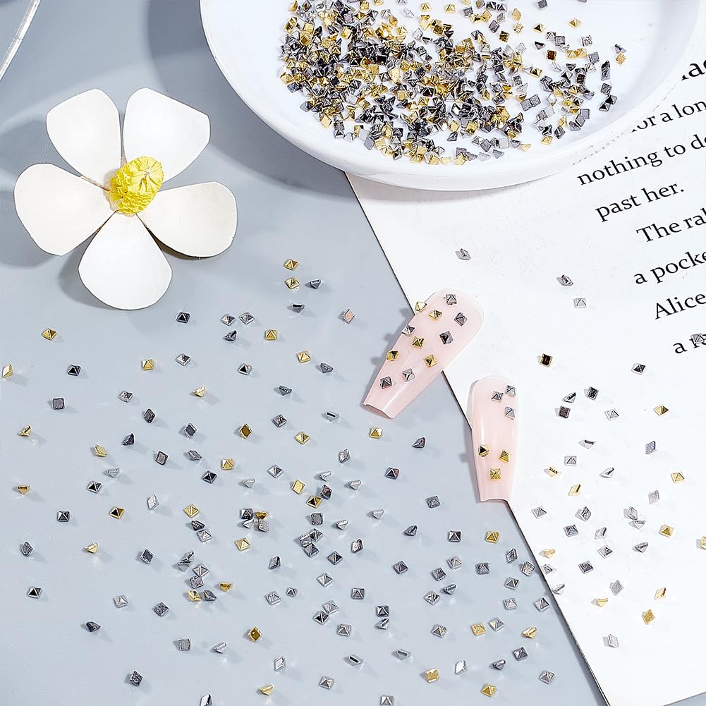 Close up of gold silver and gunmetal metallic nail studs