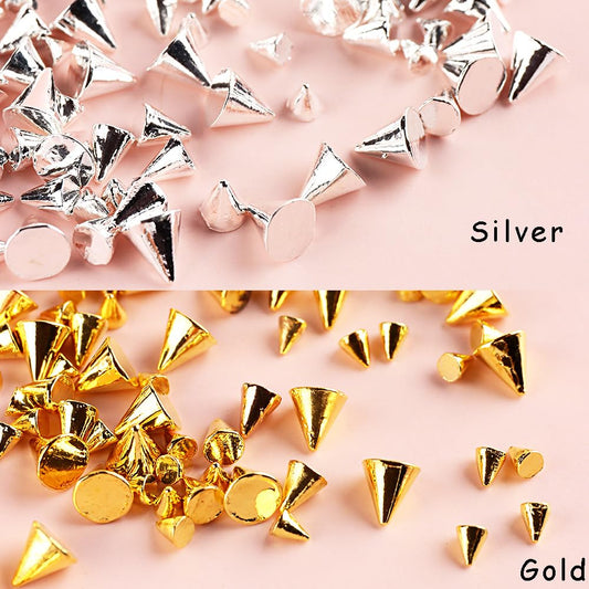 Close up view of gold and silver alloy spike studs flatback nail jewels on long acrylic nails decoration