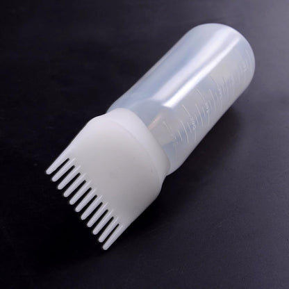 Pink squeezable plastic root applicator comb bottle highlighting flexible material construction