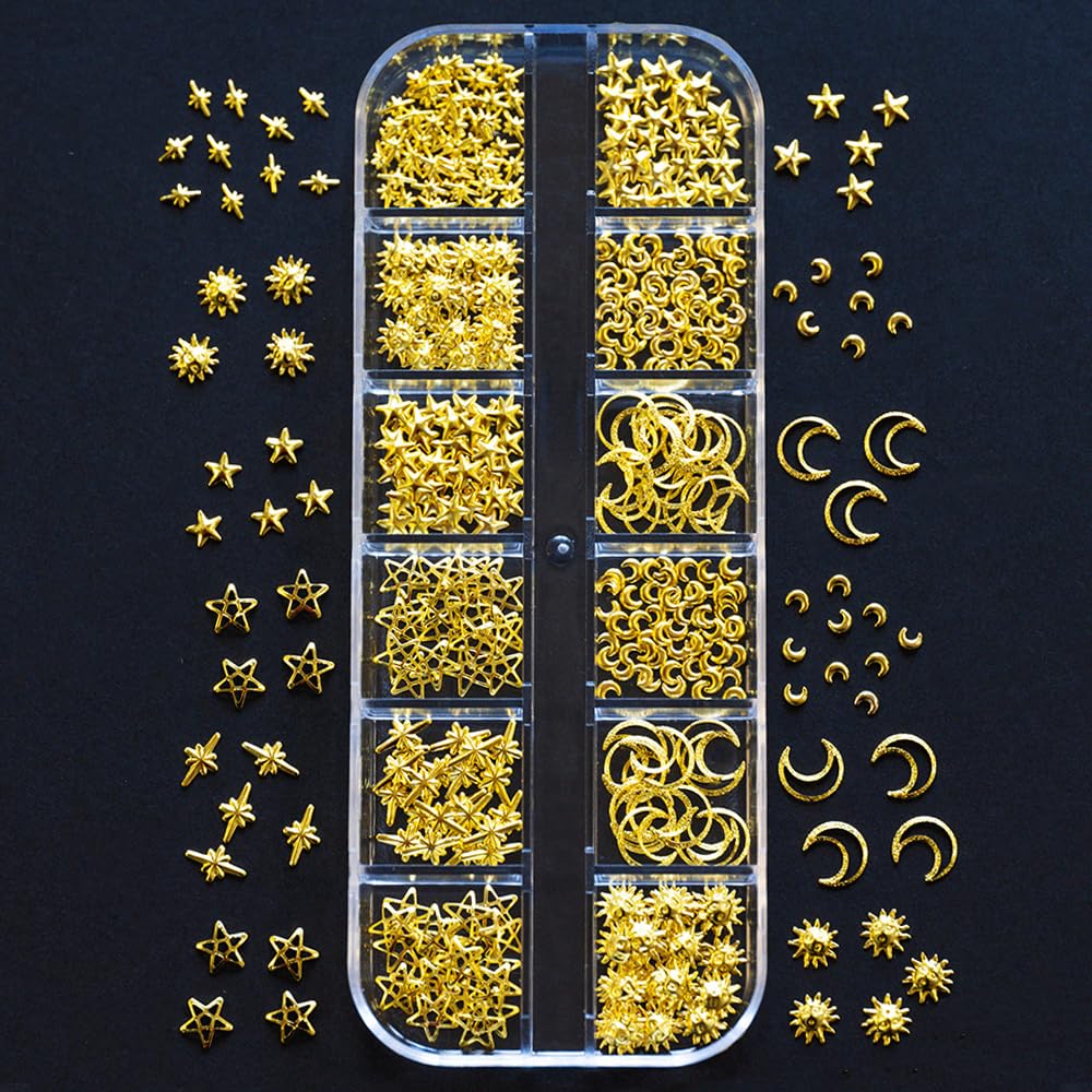 Close up view of gold moon and star alloy nail charms arranged on a manicured hand.
