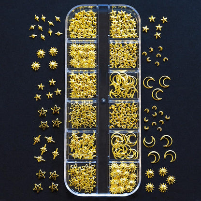 Close up view of gold moon and star alloy nail charms arranged on a manicured hand.
