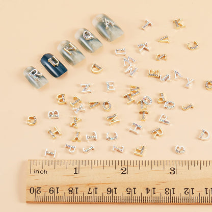 Close up look at the 3D capital letter nail decorations in glittering gold serif font style.
