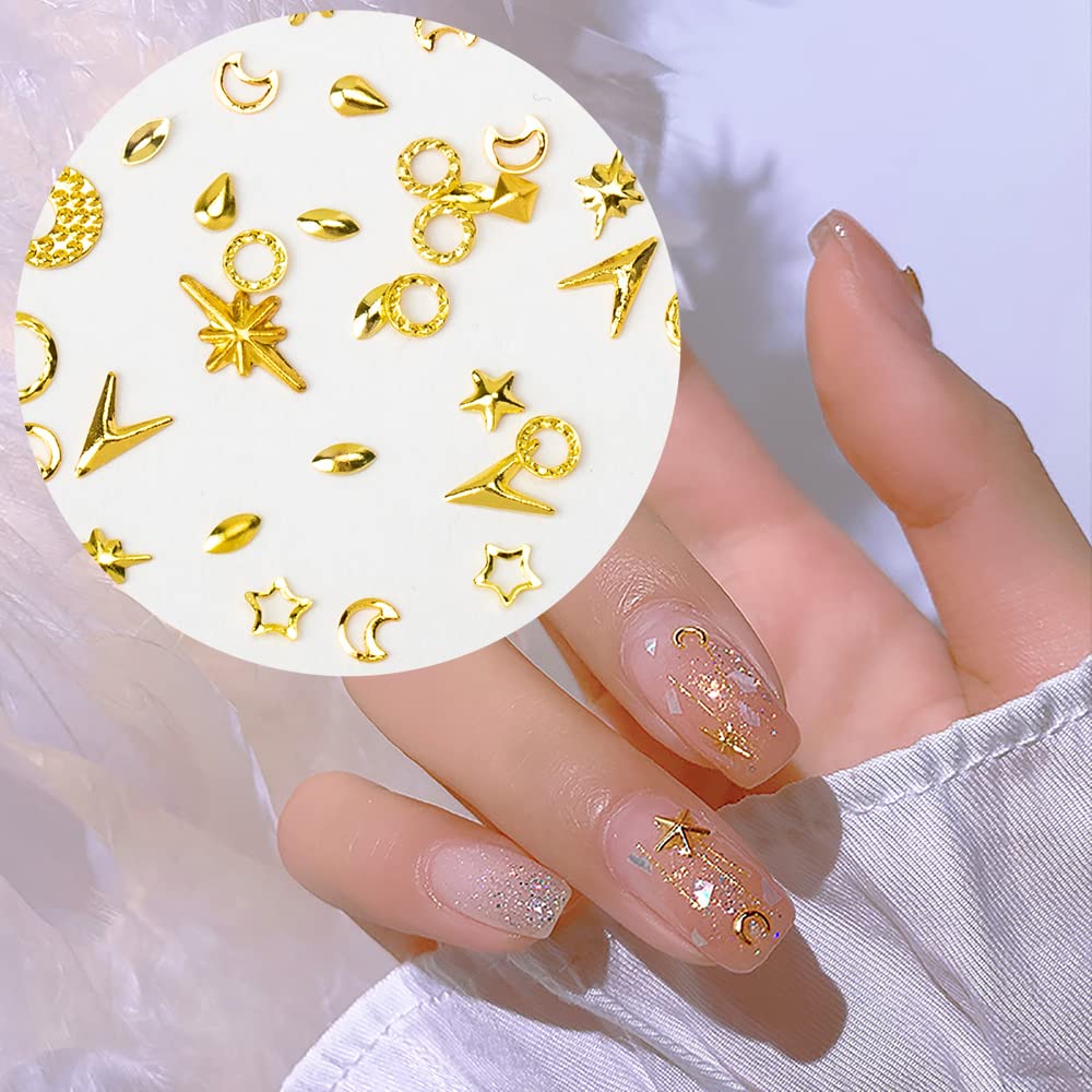 Detailed lifestyle image of acrylic manicures decorated with gold celestial charms and rhinestones