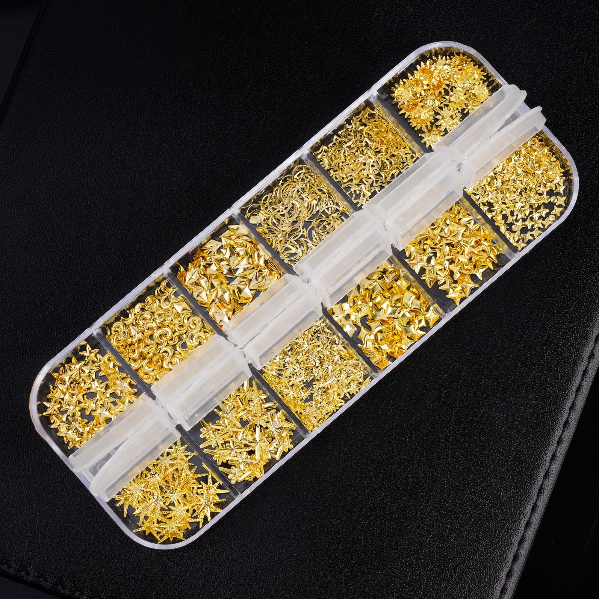 Close up of gold metal celestial nail art charms in storage box