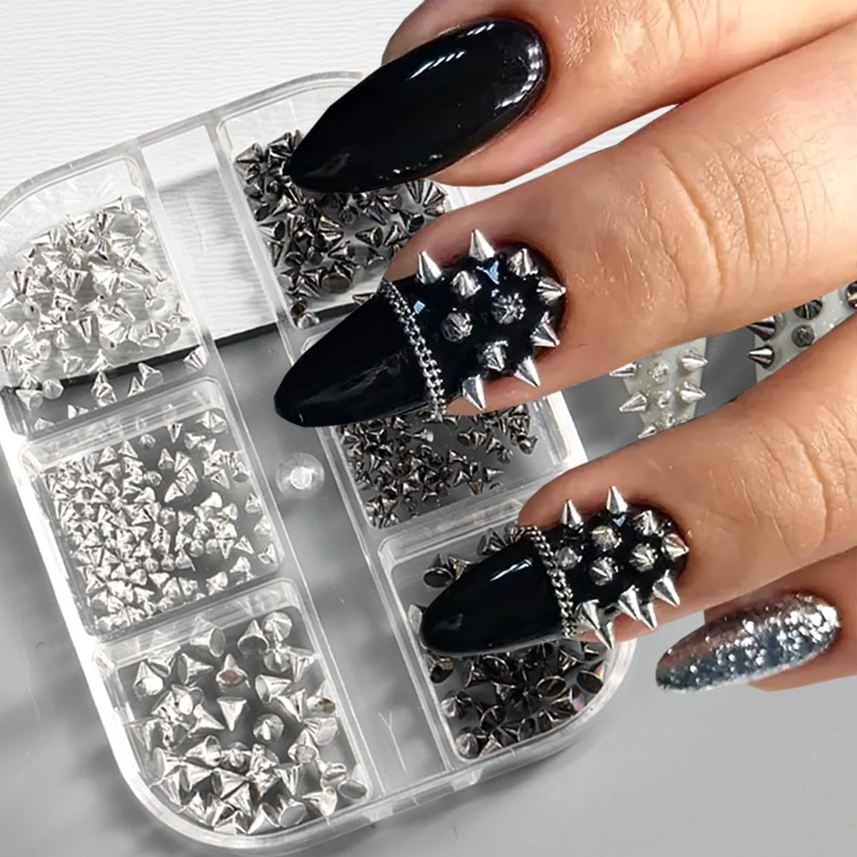 DIY nail art tools featuring metallic rivet charms on a nail tip