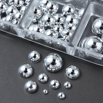 Two clear storage boxes filled with mini metal rivet punk nail charms alongside application tweezers