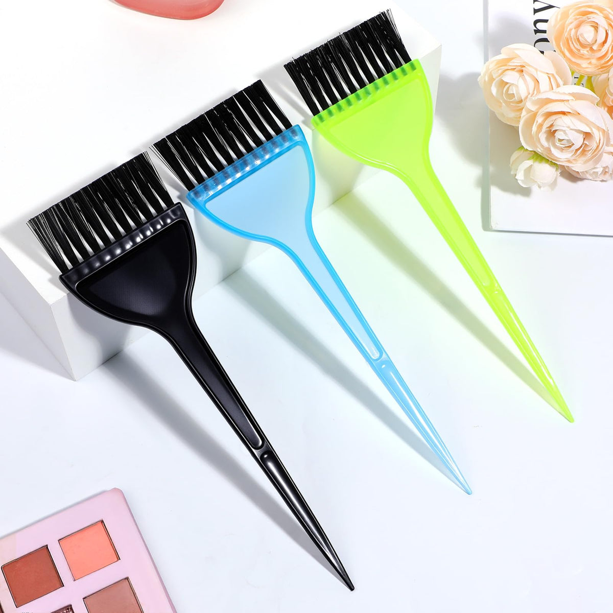 Three Aternal hair coloring brushes displayed on a salon workstation