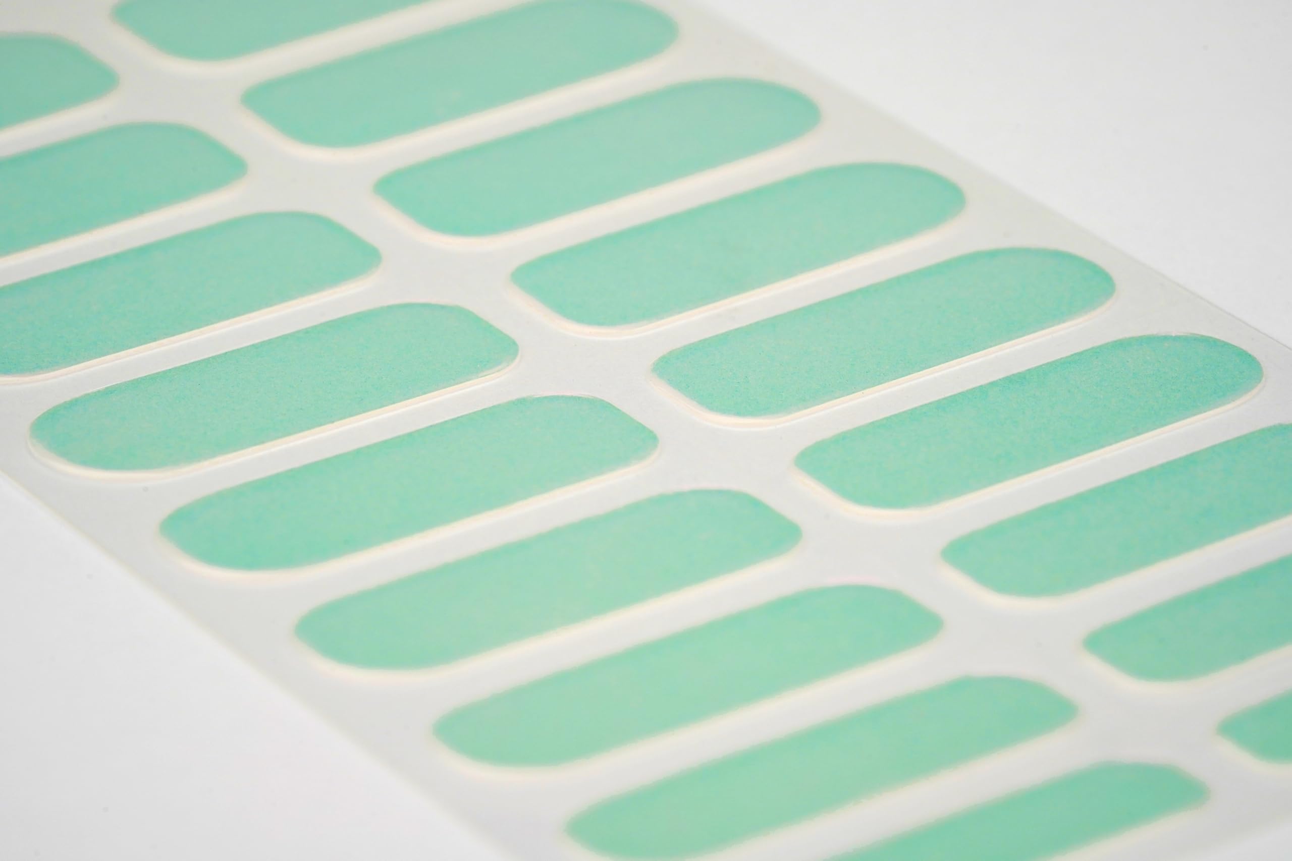 Pink and green iridescent gel nail strip design close up