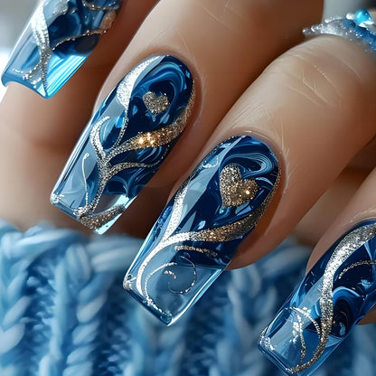 Close up of blue gel nail wraps with gold heart detail