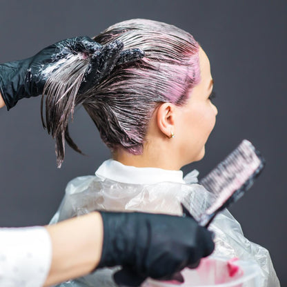 Person using Iensen disposable cape for professional hair dyeing