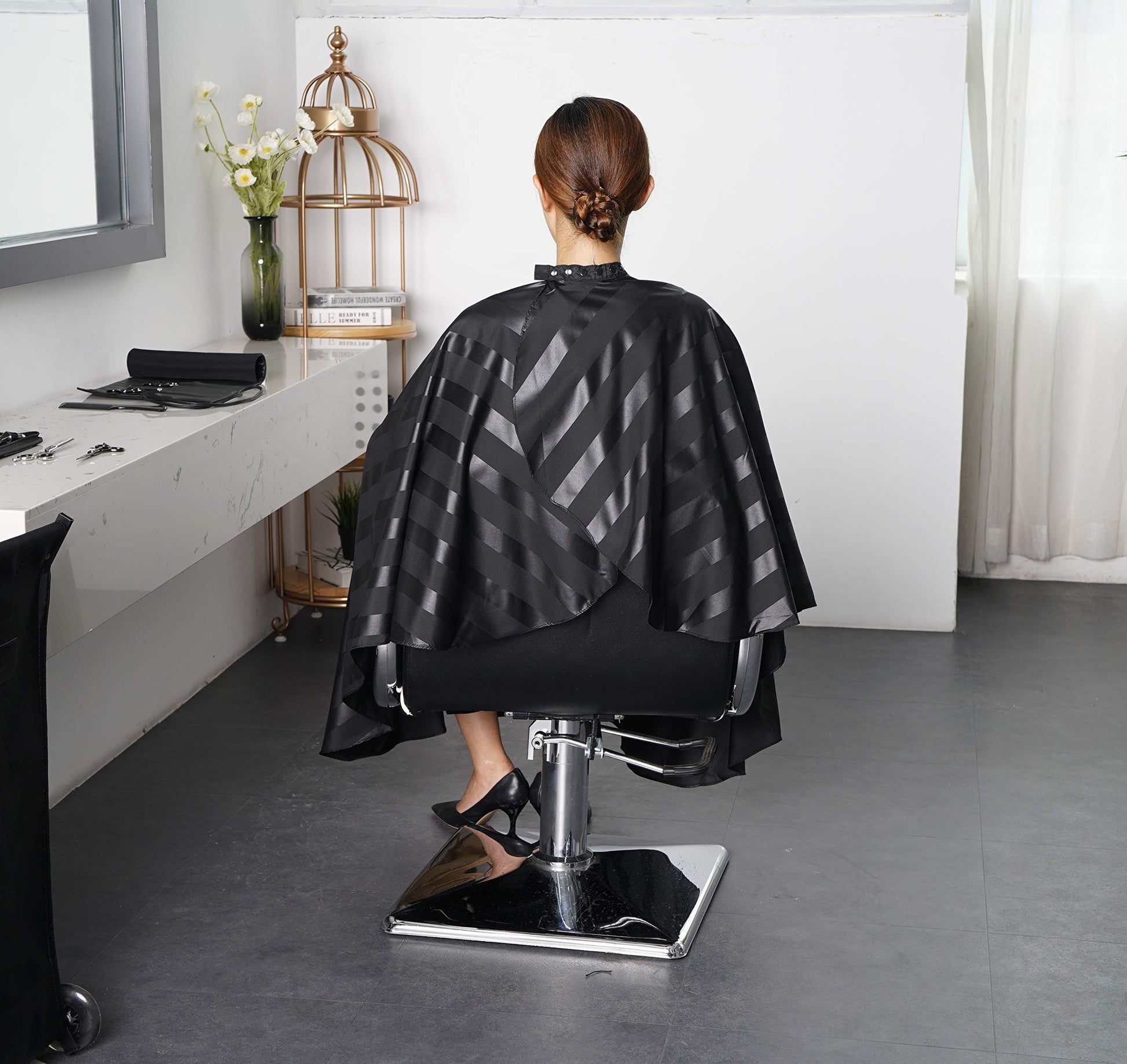 Full size black salon cape hanging for storage