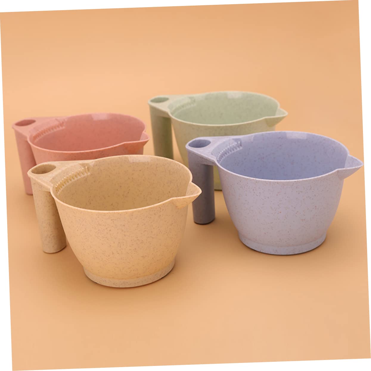 Ergonomic handles on the Minkissy plastic hair tint measuring cup for a secure grip.