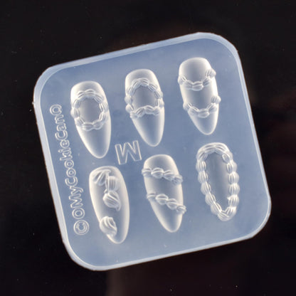 Lifoost 3D carving template showing flexible silicone material being bent to release cured resin charms.