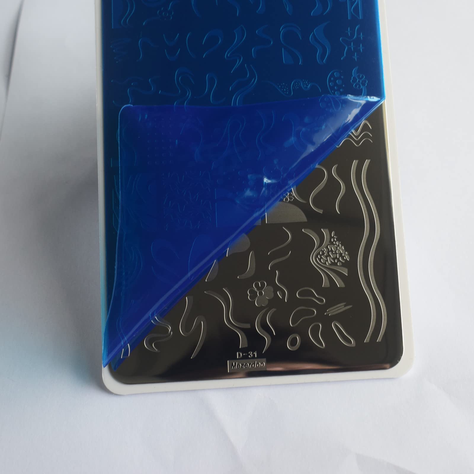 Close up of French tip nail stamp designs on metal plate