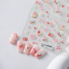 Close up of strawberry and cake bow nail art decals