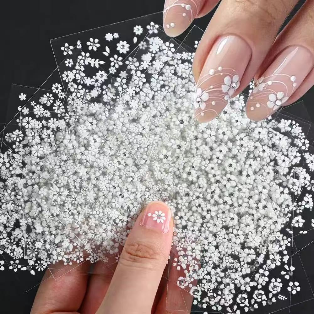 Close up of floral nail decals with rhinestones on a hand