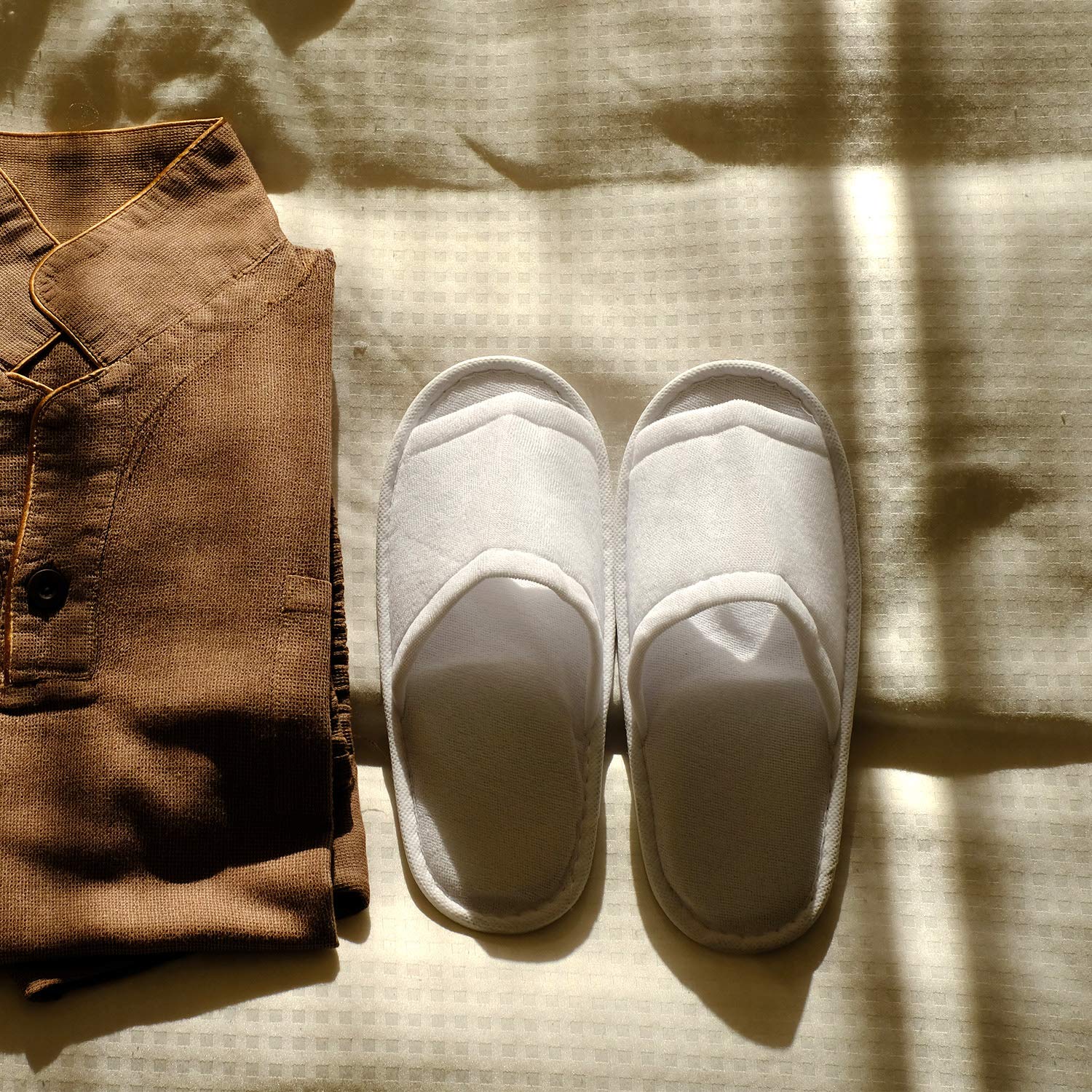 Side angle of the unisex disposable guest slipper highlighting the thick waterproof flat sole.