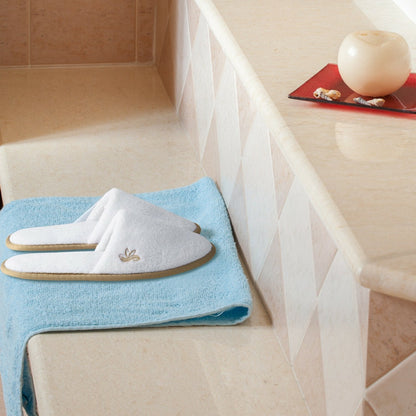 Medium and large sizes of the white premium indoor slippers showing embroidered emblem details