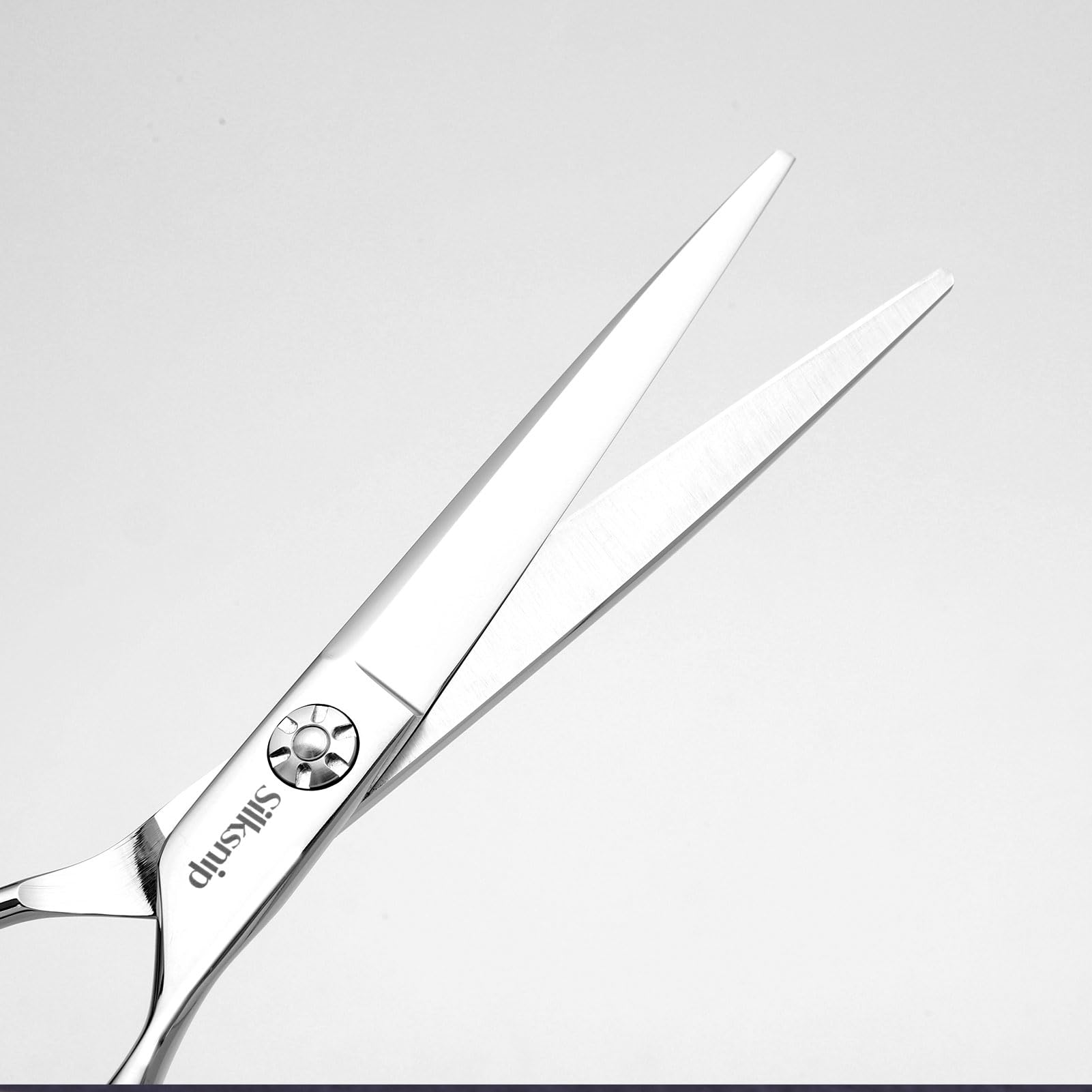 Adjustable tension screw detail on professional grade stainless steel shears