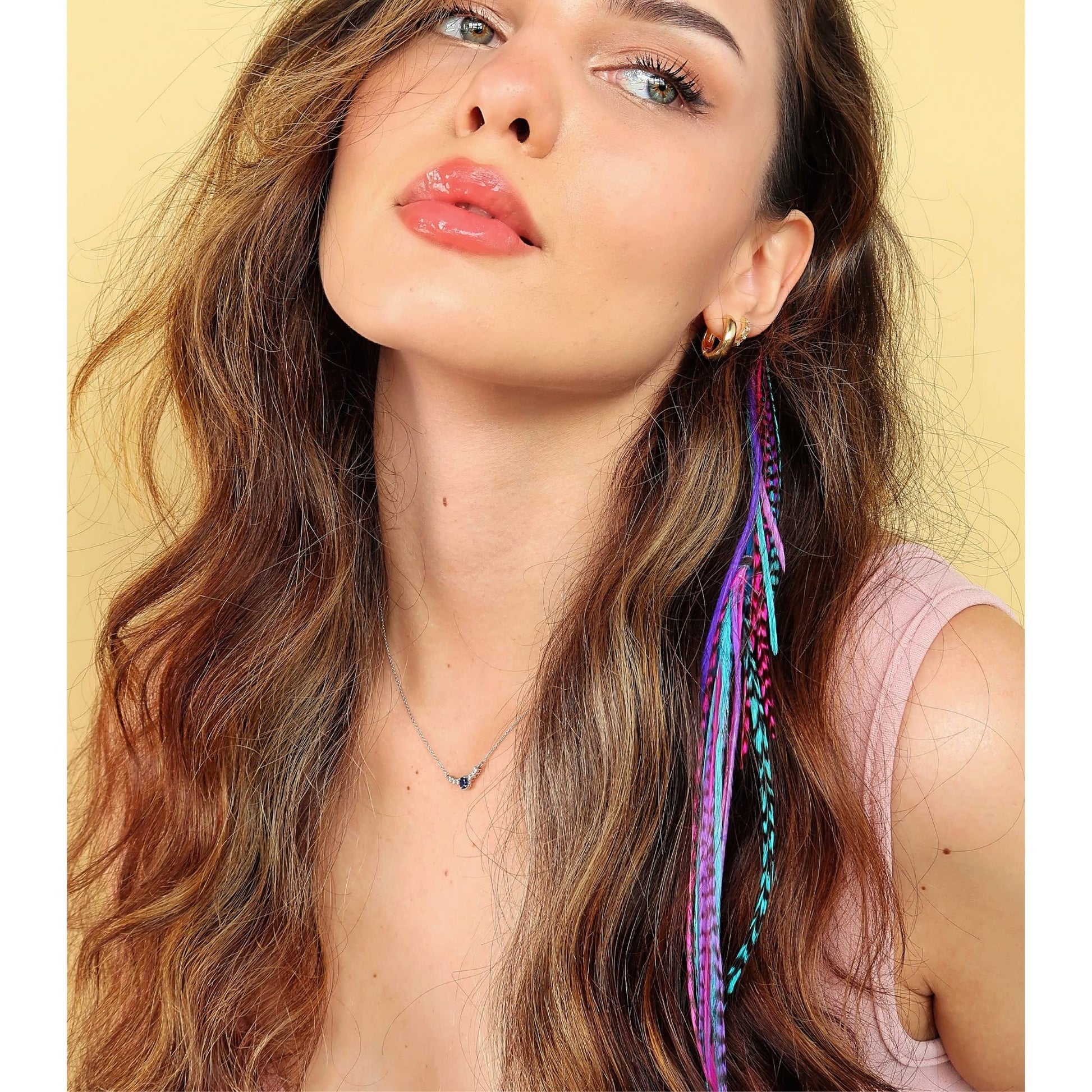 Model wearing pink blue and purple feather hair accessories