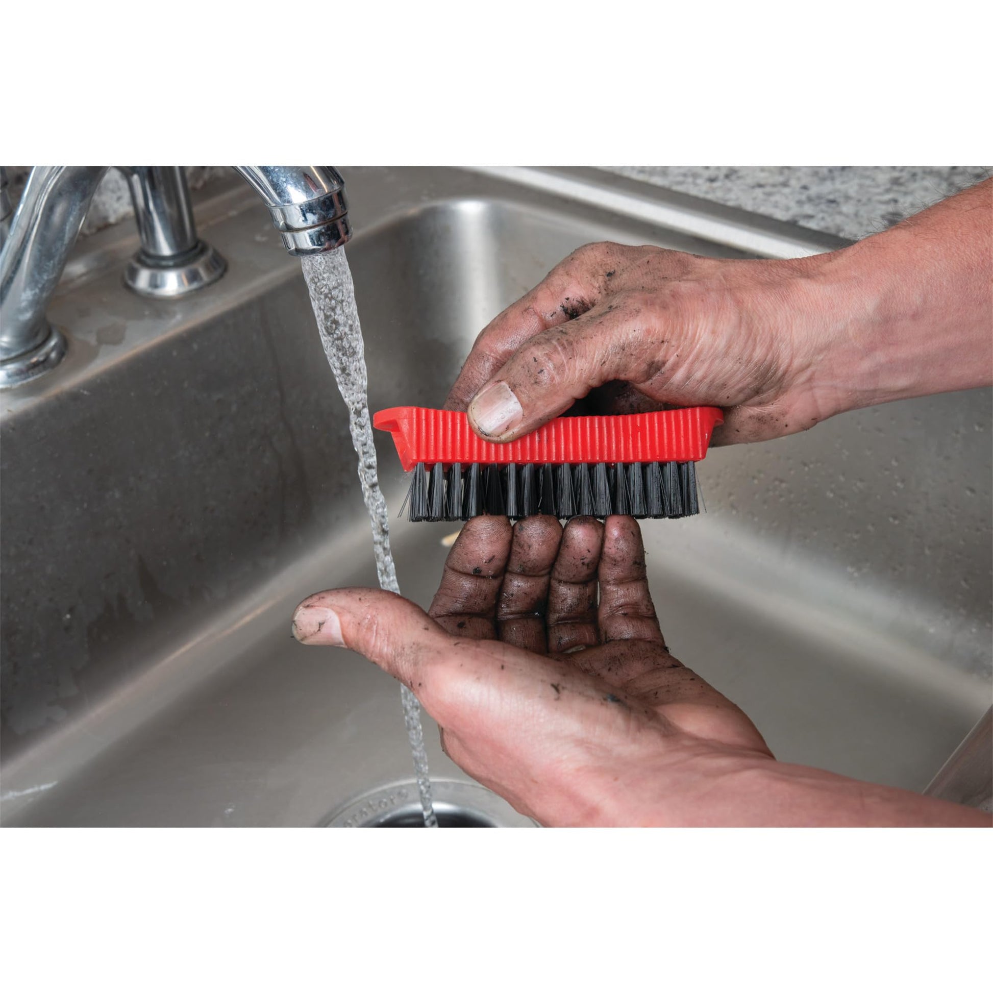 Performance Tool combo fingernail brush stored magnetically on the side of a steel garage toolbox.