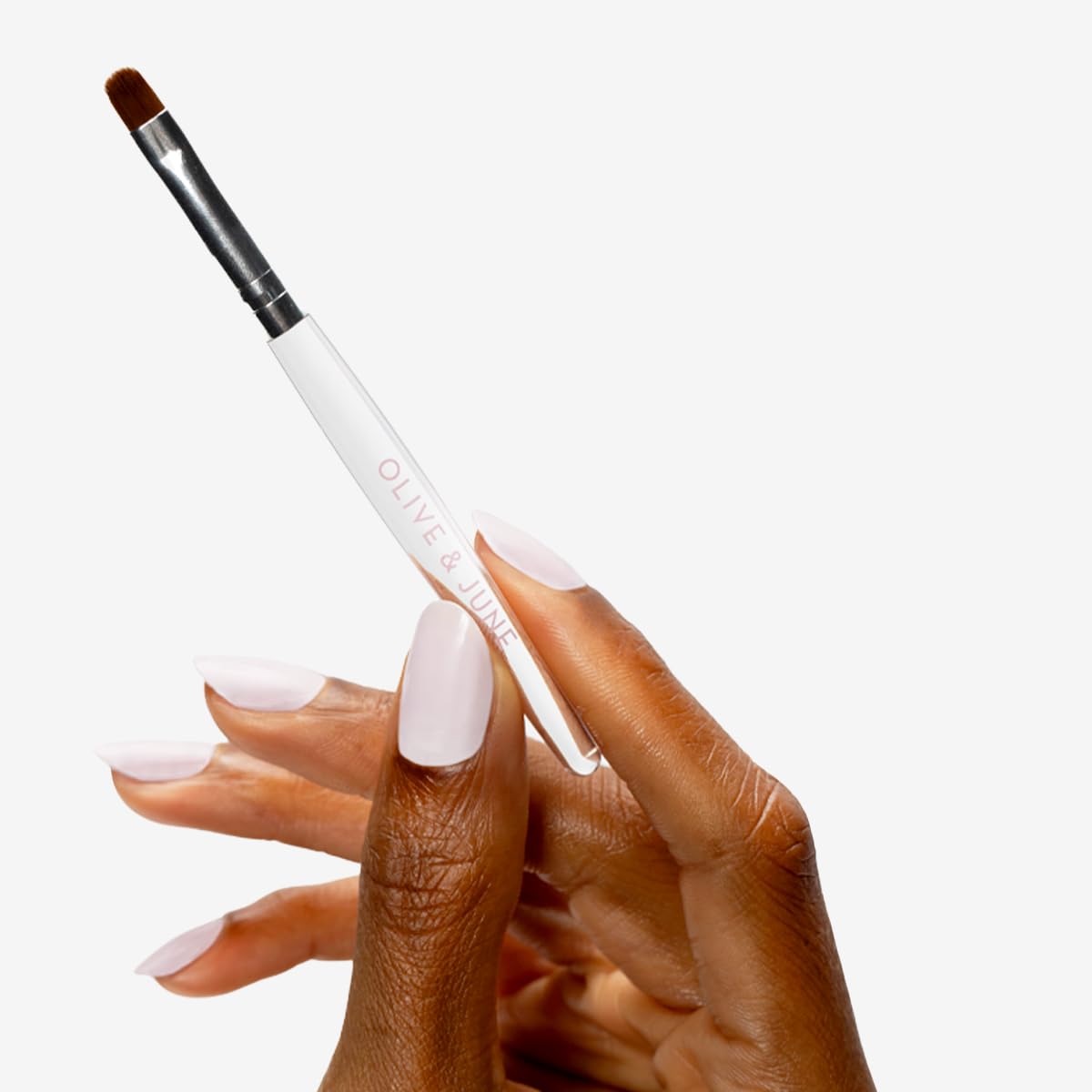 Demonstration of the flexible round nail brush cleaning stray polish along the cuticle line.