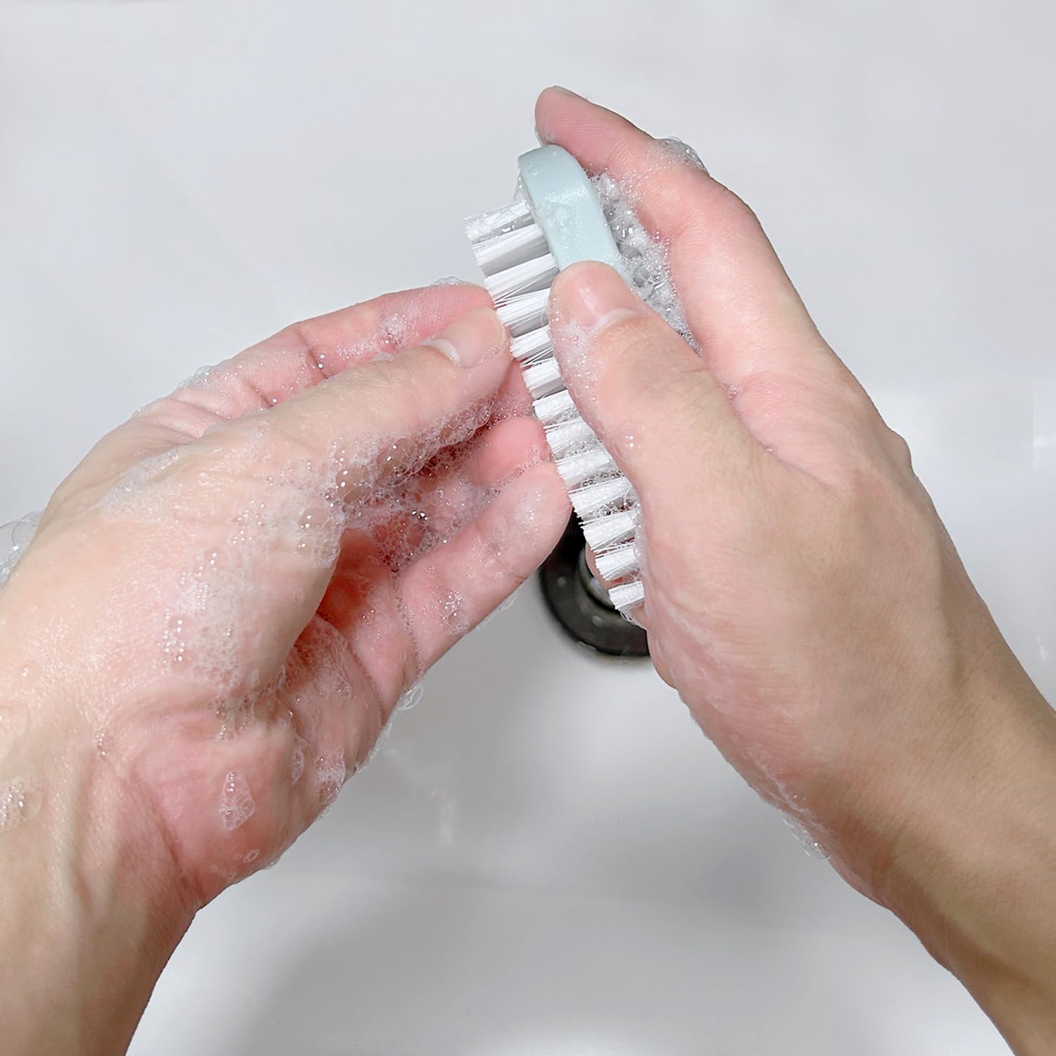 Nail brush for cleaning fingernails being held securely to demonstrate the compact non slip grip