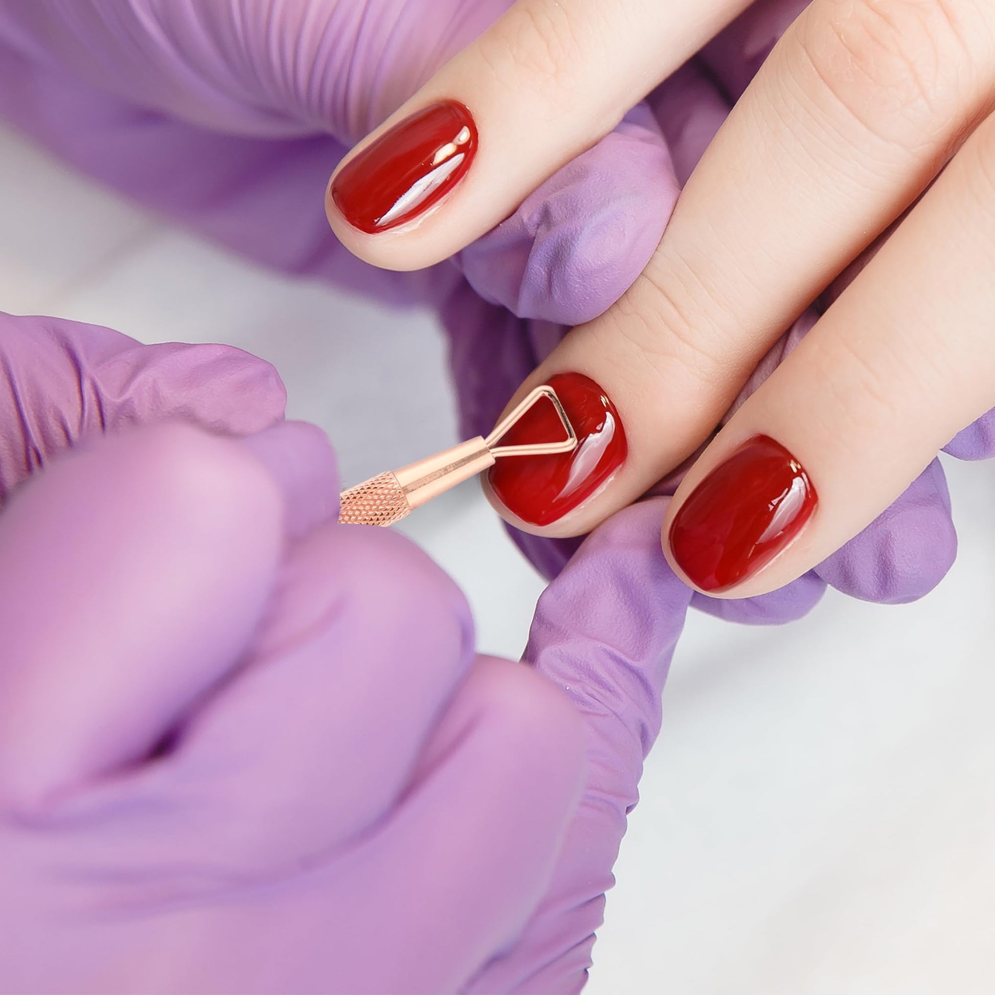 Utopia Care rainbow finish premium cuticle remover tools being sanitized with a soft cotton cloth