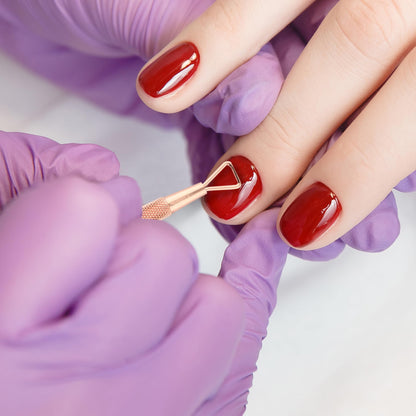 Utopia Care rainbow finish premium cuticle remover tools being sanitized with a soft cotton cloth