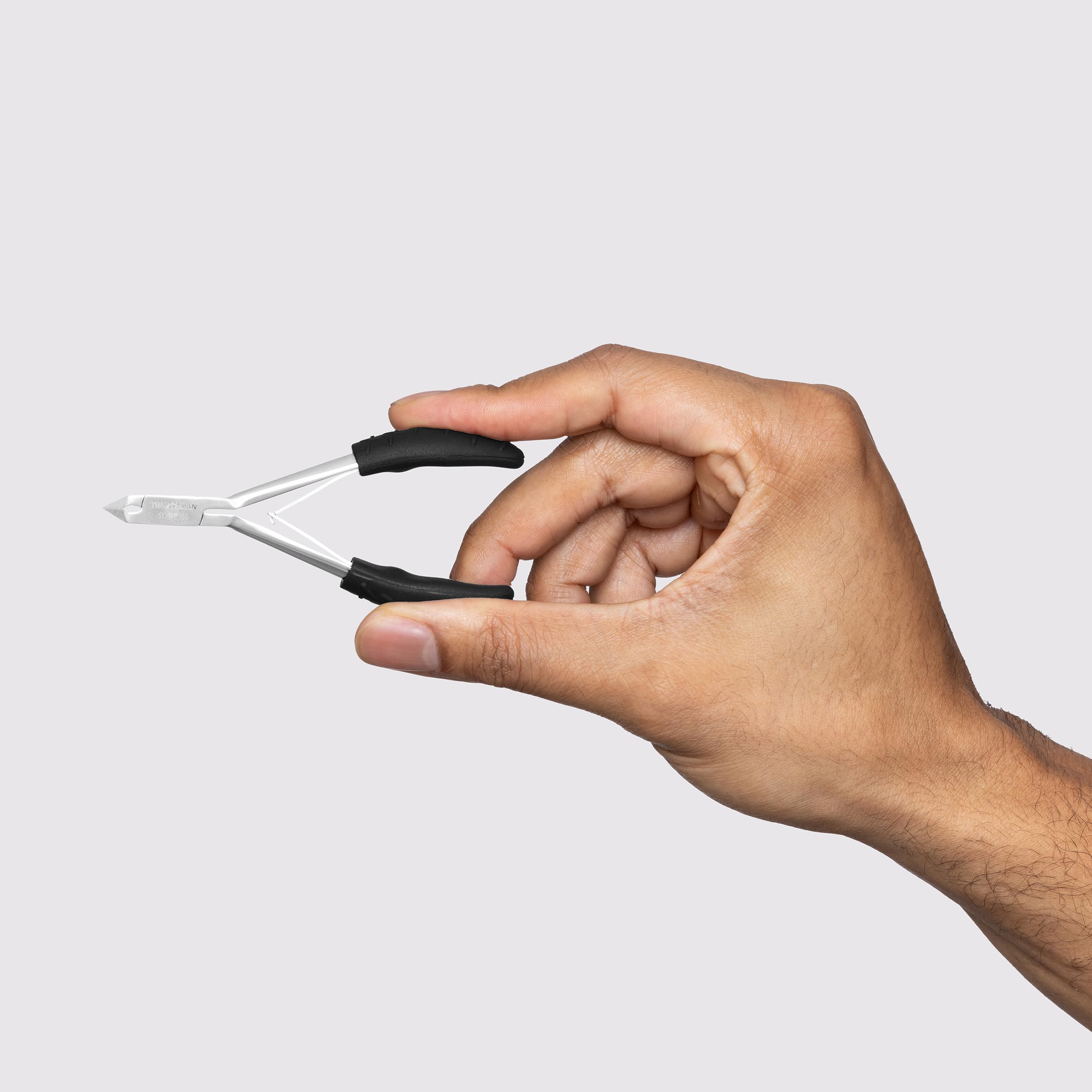 Tweezerman stainless steel cuticle tool being sanitized with an alcohol wipe for hygienic home salon care