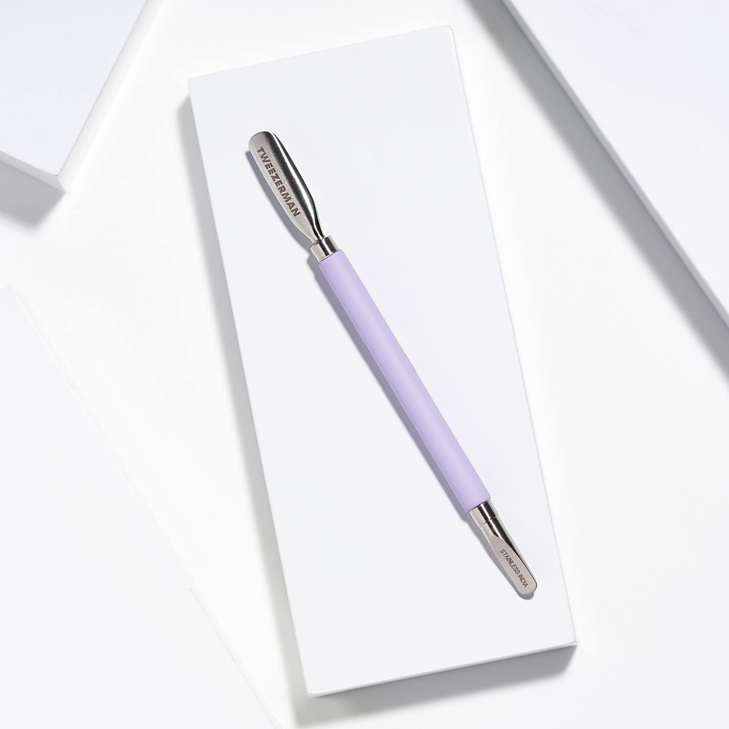 Ergonomic soft-touch handle of Tweezerman Dual Sided Pushy in purple