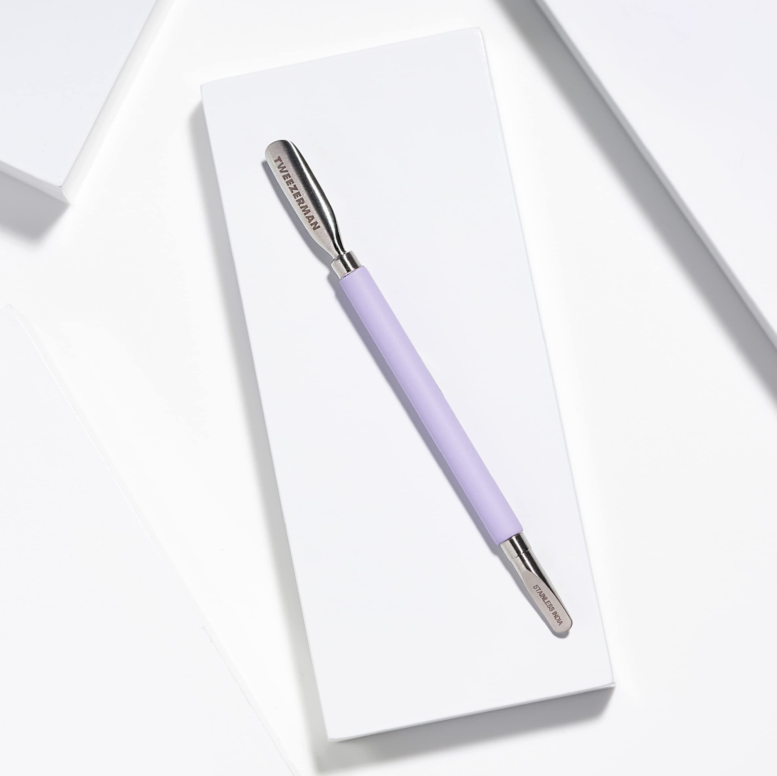 Ergonomic soft-touch handle of Tweezerman Dual Sided Pushy in purple
