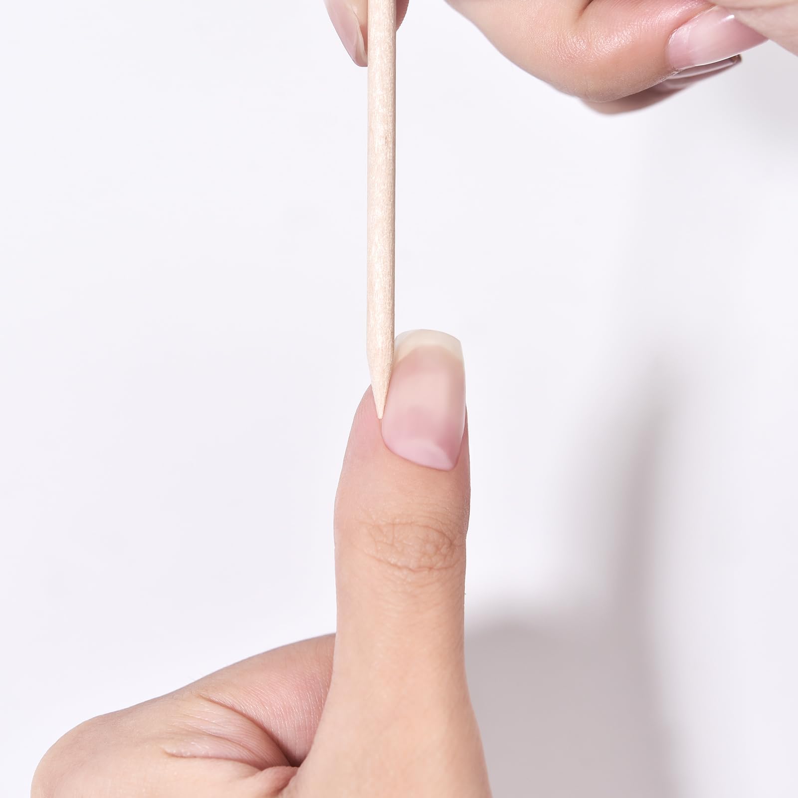 Pointed tip of wooden nail stick cleaning under fingernail