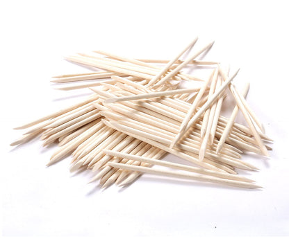 Using flat end of orange wood stick on nail cuticle