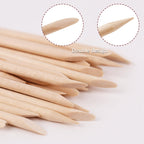 Orange wood sticks being used to clean under nails