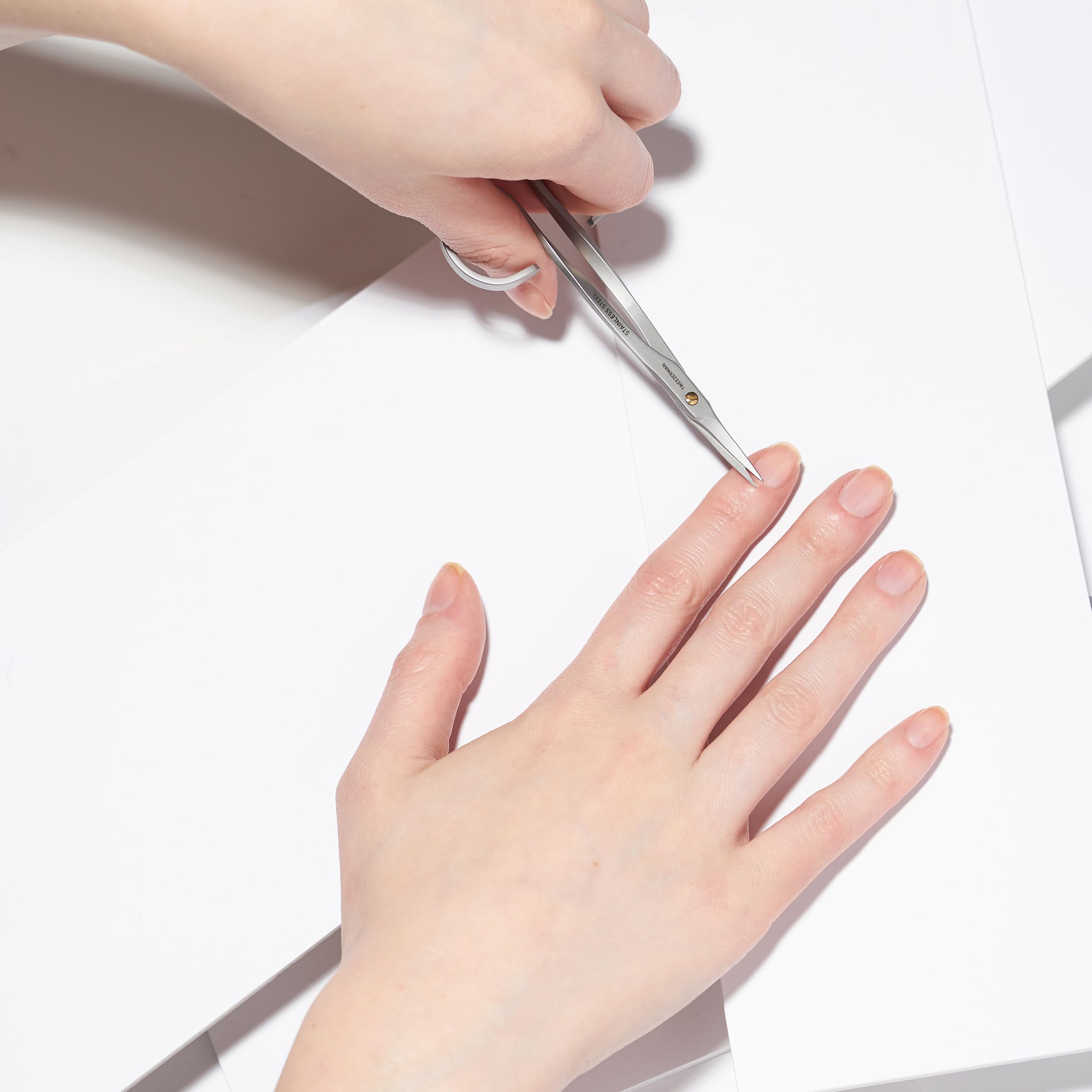 Ergonomic finger loop handles of the premium Tweezerman stainless steel grooming shears.