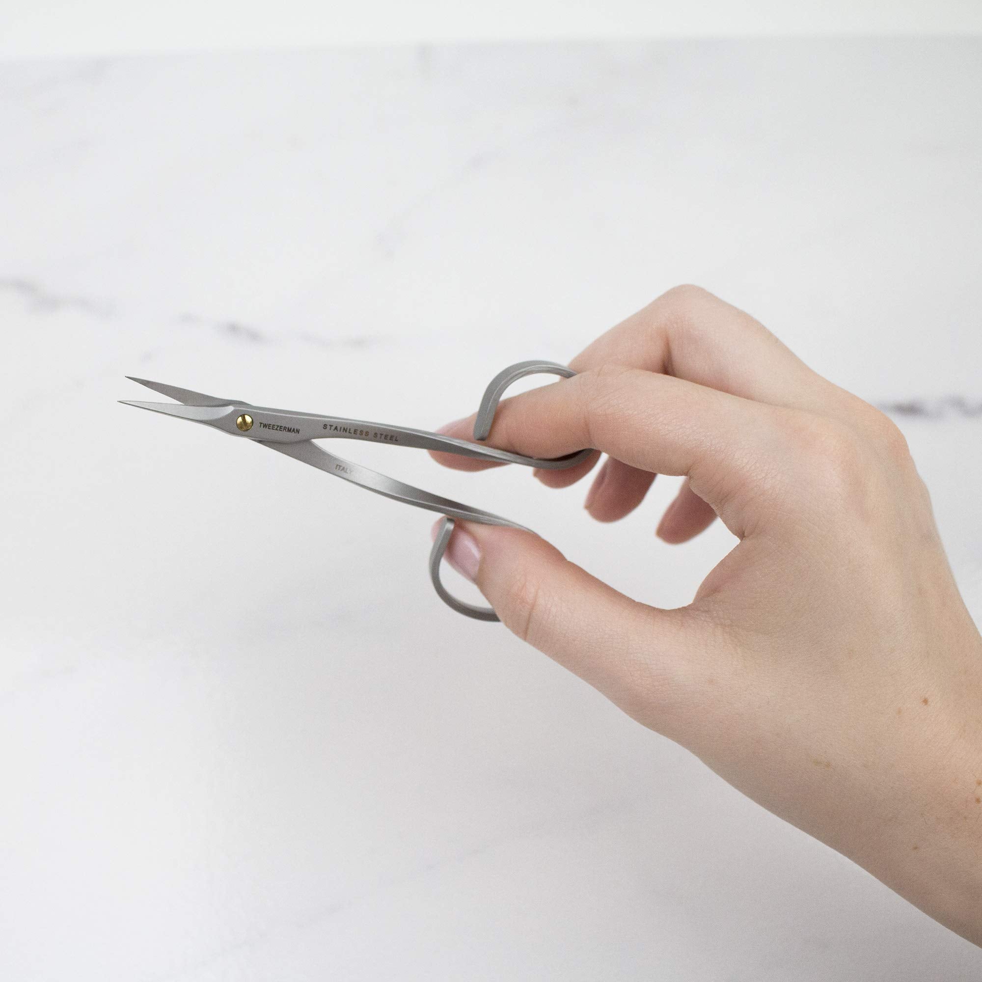 Trimming hangnails with the ultra fine tips of the durable stainless steel nail care tool.