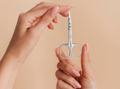 Compact travel size beauty scissors in an elegant protective pouch package.